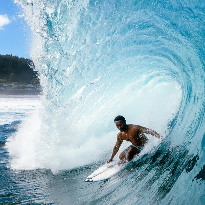 Josh Moniz slides through a crystal blue barrel at Pipeline.