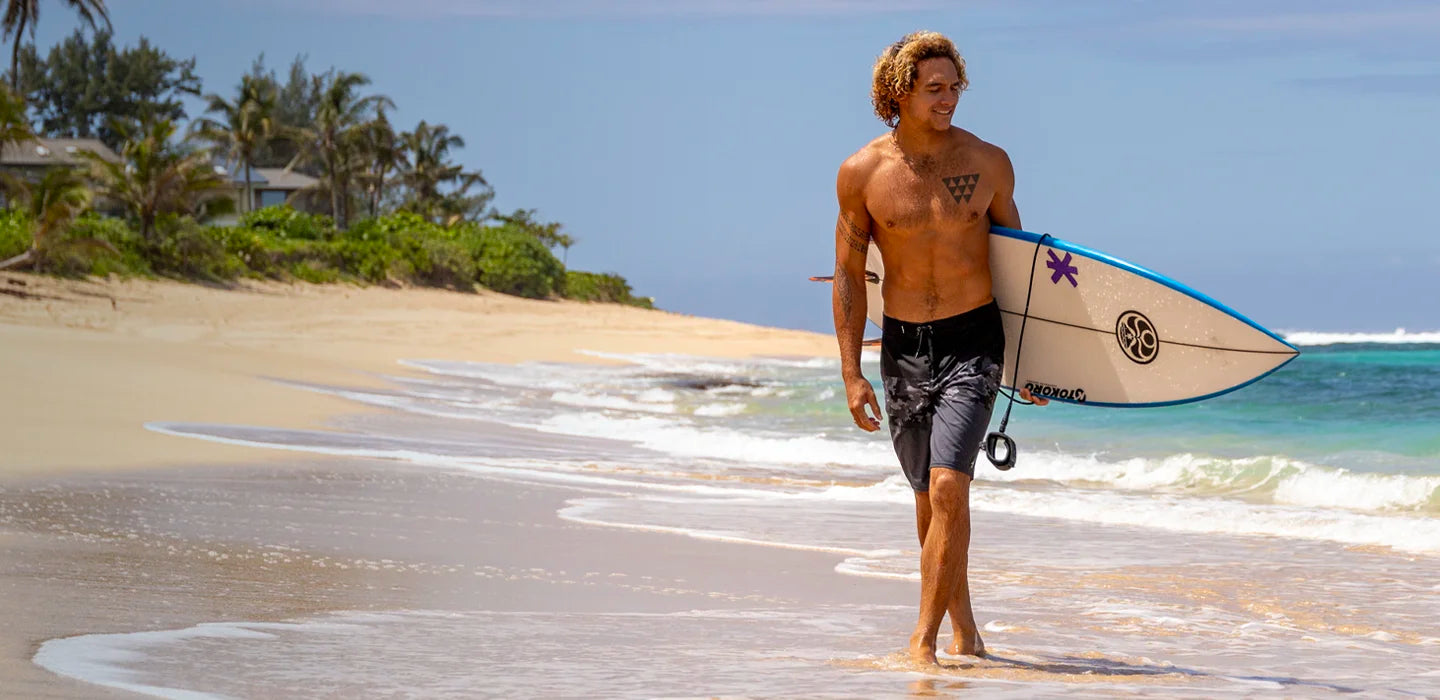 Mario cruising on the beach in O'Neill board shorts