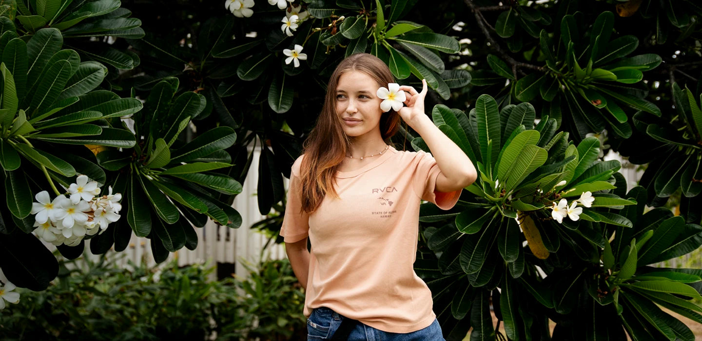 Girl with a plumeria in her hair and a RVCA tee.